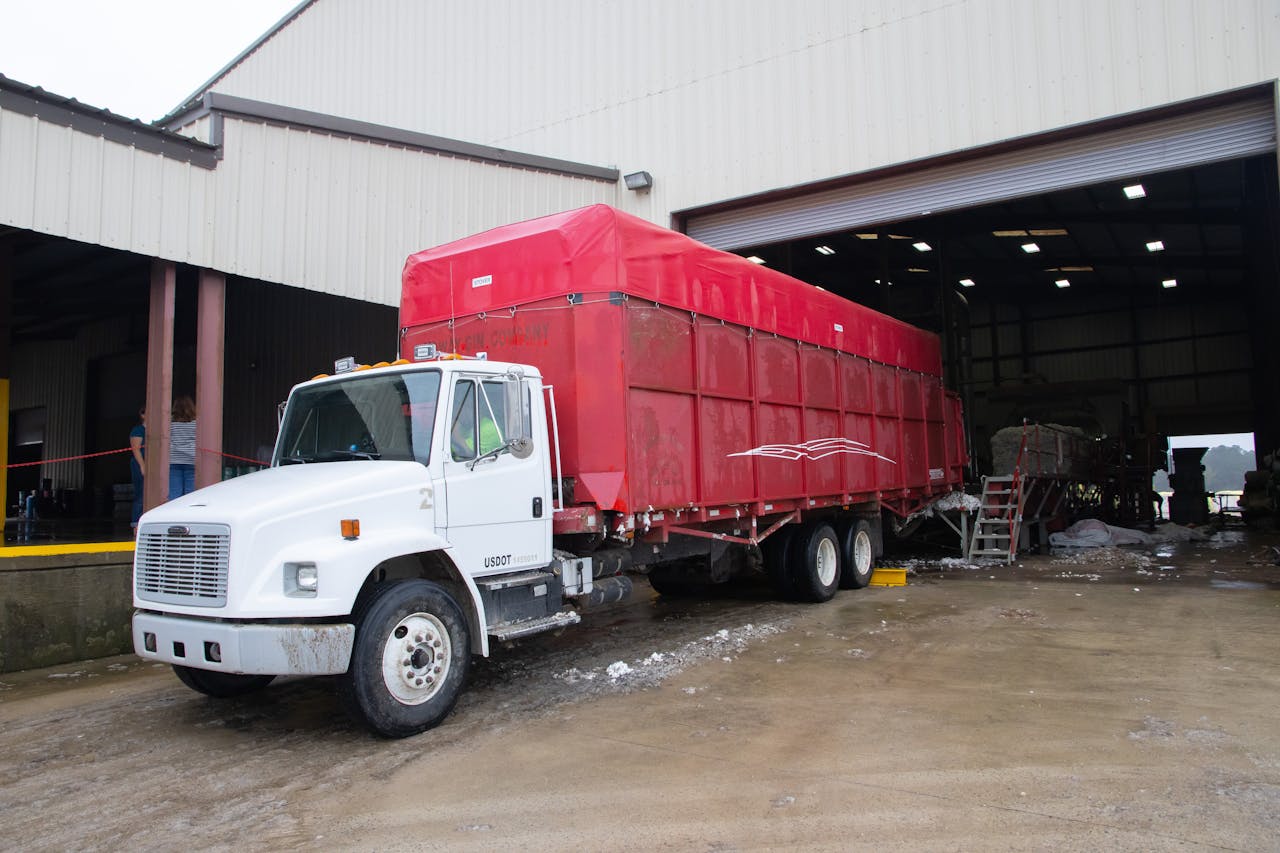 services-02 Red trailer truck at a warehouse loading dock, ready for delivery.